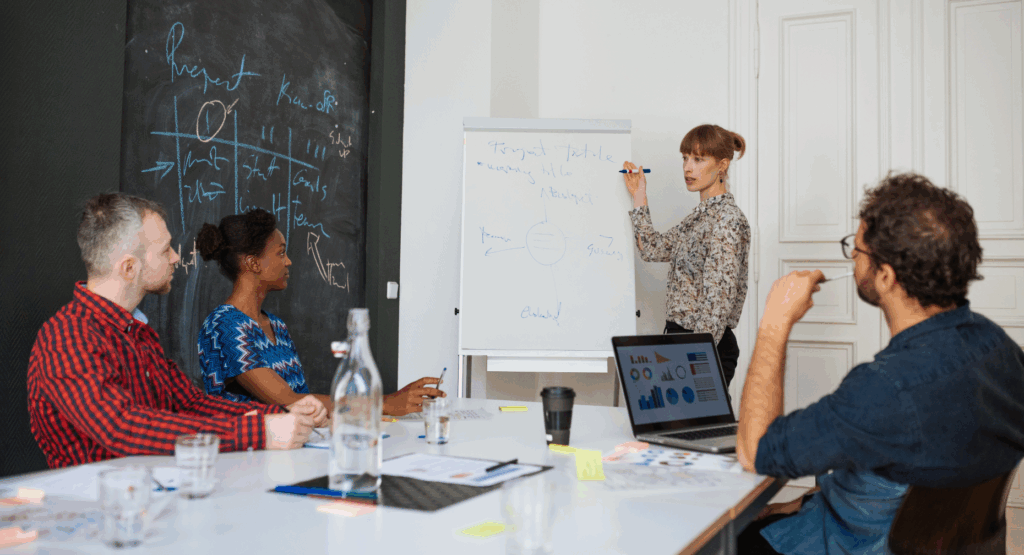 A group of professionals brainstorms in a meeting room.