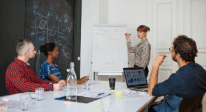 A group of professionals brainstorms in a meeting room.