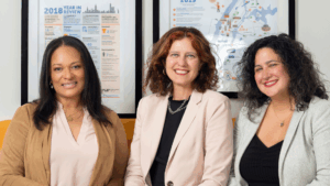 Public Works Partners Principals, Allison Quigney, Celeste Frye, and Melissa Lee, sit on a couch.